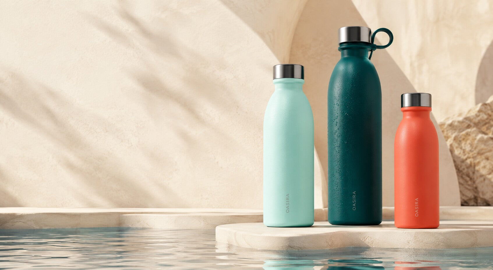 Three OASIRA reusable bottles beside a reflective water surface